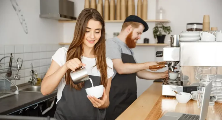 Minijob: Zwei Mitarbeiter arbeiten im Cafe und schenken Kaffee in eine Tasse ein