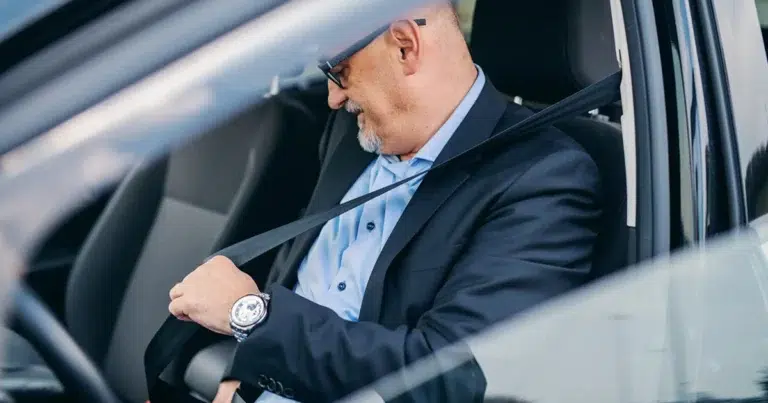 Pendlerpauschale: Arbeitnehmer schnallt sich vor Fahrt zur Arbeit im Auto an